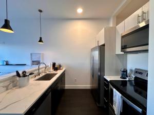 a kitchen with a sink and a refrigerator at Modern Studio Apt with Skywalk to Fiserv, Rooftop, and Parking in Milwaukee +28 photos