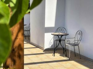 a table and two chairs sitting next to a wall at Masseria Lu Monaco in Melendugno