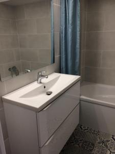 ein Badezimmer mit Waschbecken, Badewanne und Spiegel in der Unterkunft La caravelle in Juan-les-Pins