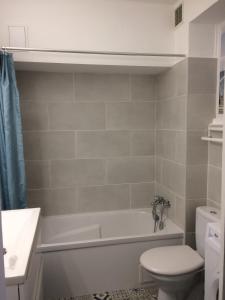 ein Badezimmer mit Badewanne, Toilette und Waschbecken in der Unterkunft La caravelle in Juan-les-Pins