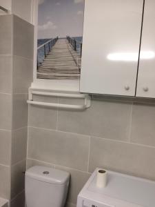 ein Bad mit WC und ein Bild von einem Pier in der Unterkunft La caravelle in Juan-les-Pins