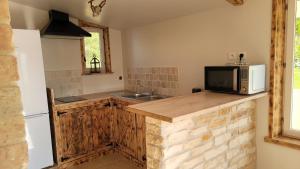 a kitchen with a counter with a microwave and a sink at Gite au cœur du dday in Carentan