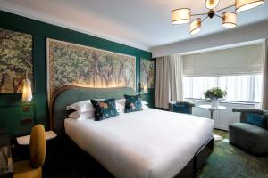 a bedroom with a large bed and a large painting on the wall at The Capital Hotel, Apartments & Townhouse - Small Luxury Hotels of The World in London