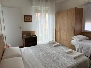 Un dormitorio con dos camas y una ventana. en Affittacamere Casa Mia, en Verona