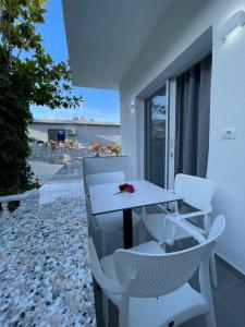 a table and chairs on a balcony with a view of the beach at Vila Ori in Ksamil