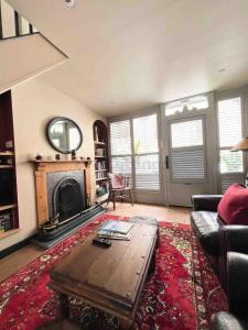 a living room with a coffee table and a fireplace at Old Bookshop - Unique house in central St Ives with outdoor space in St Ives