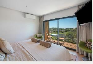 a bedroom with a large bed and a balcony at Tiny house in São Brás de Alportel