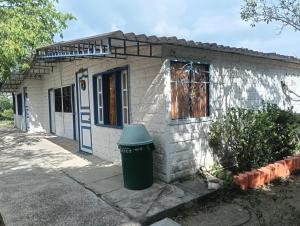 a small house with a trash can in front of it at Hostal BioHotel Caribe Green in Santa Marta