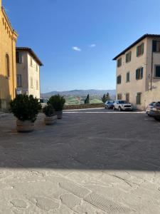 a parking lot with potted plants and buildings at Casa Vacanze Michelangelo in Laterina +7 photos