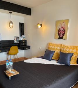 a bedroom with a bed with blue pillows and a table at Lever du soleil in La Trinité +24 photos