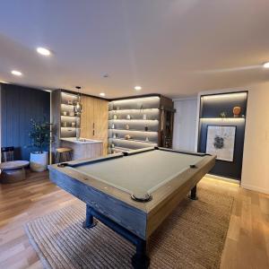 Una habitación con una mesa de billar y una habitación con estanterías. en Clínica Bupa y Davila Estadio Monumental y Mall Cenco Florida, en Santiago