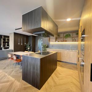 una cocina con armarios de madera y una isla de cocina con sillas en Clínica Bupa y Davila Estadio Monumental y Mall Cenco Florida, en Santiago 54 fotos más