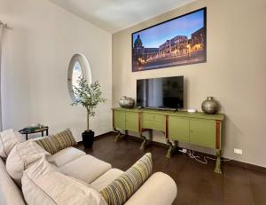 un soggiorno con un divano e una TV a schermo piatto di Flat44 a Palermo