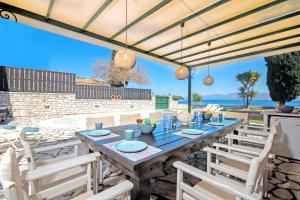 a patio with a wooden table and chairs at Villa Annie by Villa Plus in Kassiopi
