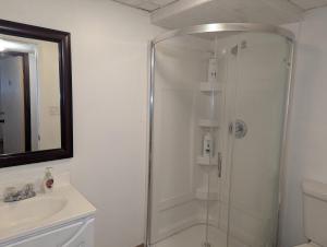 a shower with a glass door in a bathroom at Calgary Star Cozy Home in Calgary +50 photos