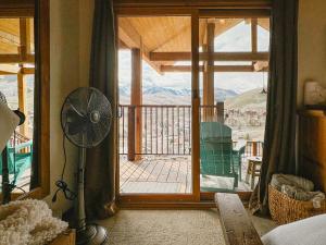 ein Zimmer mit einem Ventilator und einer Tür zu einem Balkon in der Unterkunft Highest Condo in CB with Stunning Views from Porch in Crested Butte + 25 Fotos