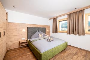 een slaapkamer met een groot bed in een kamer bij BEIM LOIS Edelweiss - AlpenLuxus Collection in Gerlos