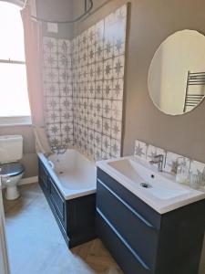 a bathroom with a tub and a sink and a mirror at Annie's Place in Saltburn-by-the-Sea +2 photos