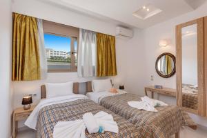 two beds in a room with a mirror and a window at Villa Chrysa by Villa Plus in Hersonissos +15 photos