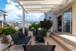 a patio with chairs and tables on a balcony at Sunny Terrace - Apartment Zulim, Trogir in Trogir