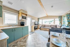 a kitchen and living room with a couch and a table at Sunset Sands - Hayling Island in South Hayling