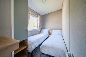 two beds in a small room with a window at Dune Delight - Hayling Island in South Hayling +26 photos