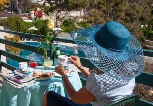 a woman sitting at a table with a cup of coffee at Hotel Terminal - Caroli Hotels in Leuca