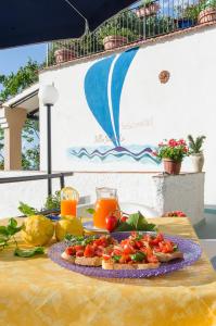 un plato de comida en una mesa con frutas y hortalizas en Villa Raffaela B&B, en Isquia