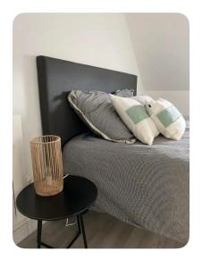 un letto con due cuscini e un tavolo accanto ad esso di Maison dans les dunes a Le Touquet-Paris-Plage