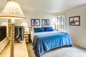 a bedroom with a bed and a lamp and a fireplace at Walk to Sun Valley Village Condo with Deck! in Sun Valley