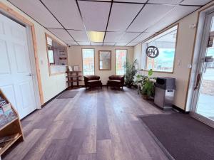 里弗顿Tomahawk Motor Lodge By OYO Riverton US-26的办公室,走廊上设有椅子和门