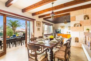 a dining room with a wooden table and chairs at Villa Es Pins by Villa Plus in Son Carrio