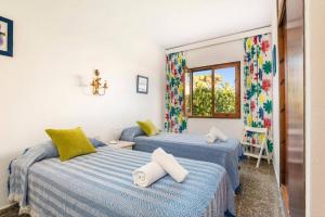 a bedroom with two beds and a window at Villa Es Pins by Villa Plus in Son Carrio +22 photos