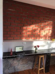 un comptoir avec un ordinateur portable sur un mur de briques dans l'établissement Casa de Marguito, à Urubamba