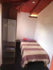 - une petite chambre avec un lit et une étagère dans l'établissement Casa de Marguito, à Urubamba