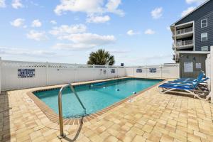 a swimming pool with a blue chair and a chair at The Beach Is Back in Myrtle Beach
