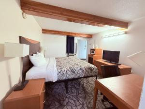里弗顿Tomahawk Motor Lodge By OYO Riverton US-26的小房间设有床、书桌和电脑