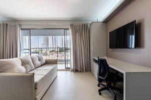 a living room with a couch and a desk at Studio NOVO na Vila Mariana! in Sao Paulo