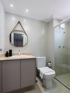 a bathroom with a toilet and a sink and a mirror at Studio NOVO na Vila Mariana! in Sao Paulo