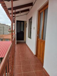 a balcony of a house with a wooden door at Céntrico Departamento de 1 Dorm in Sucre