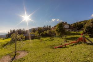 a field with a playground with a slide at Berghotel zum Zirm in Collalbo