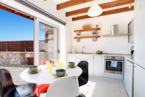 a kitchen with a table and chairs in a kitchen with a window at Villa Dione Seastone by Villa Plus in Kiotari