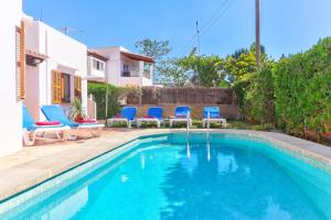 basen z niebieskimi krzesłami obok domu w obiekcie Villa Antonia Sol by Villa Plus w mieście Cacla D'or