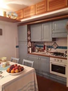 a kitchen with a bowl of fruit on a table at Luxury Sea View Apartment 100 mt Mare in Costa Paradiso +24 photos