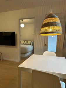 a living room with a white table and a bedroom at Petit hôtel Limoilou Studio B - Cozy et central in Quebec City