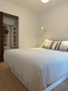 a bedroom with a large white bed in a room at Petit hôtel Limoilou Studio B - Cozy et central in Quebec City