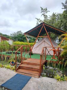 布加La Villa Glamping的带有木制门廊和桥梁的帐篷