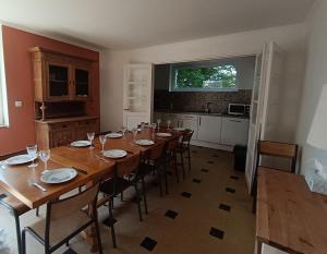 a dining room with a large wooden table with chairs at Les gîtes du Manoir de Camblain in Camblain-lʼAbbé +7 photos