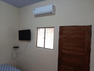 a bedroom with a door and a window and a air conditioner at Suite das Mangueiras I in Soure