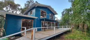 a blue house with a large deck at La Casona De Junia in Puerto Rico
